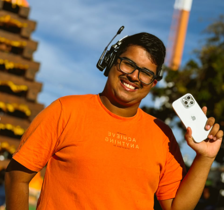 Talles em cobertura externa, usando equipamento de áudio e segurando o celular